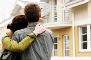 Happy couple in front of their new home