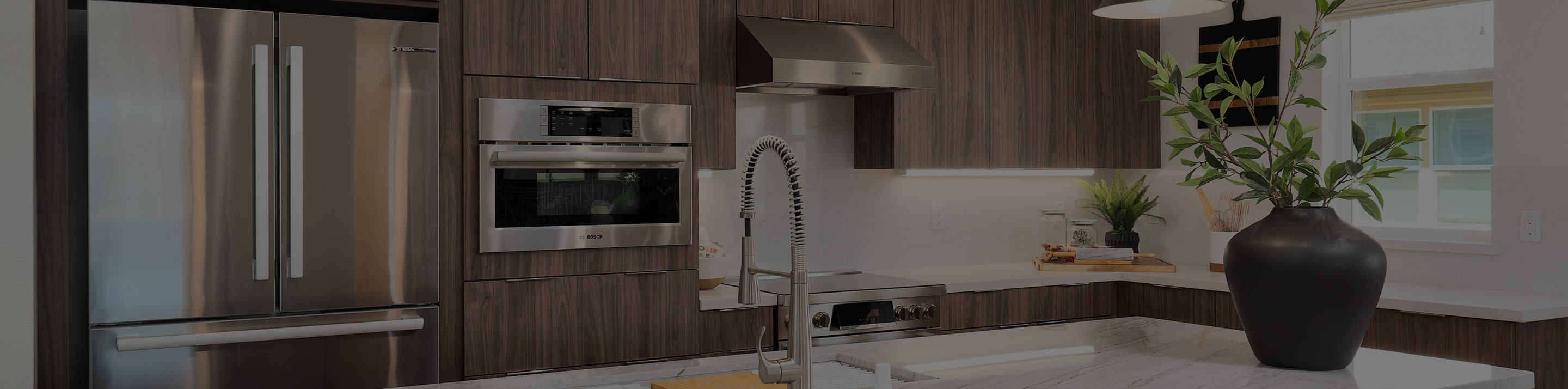 Modern kitchen and living area by SummerHill Homes featuring a large island with seating, stainless steel appliances, and open-plan design.