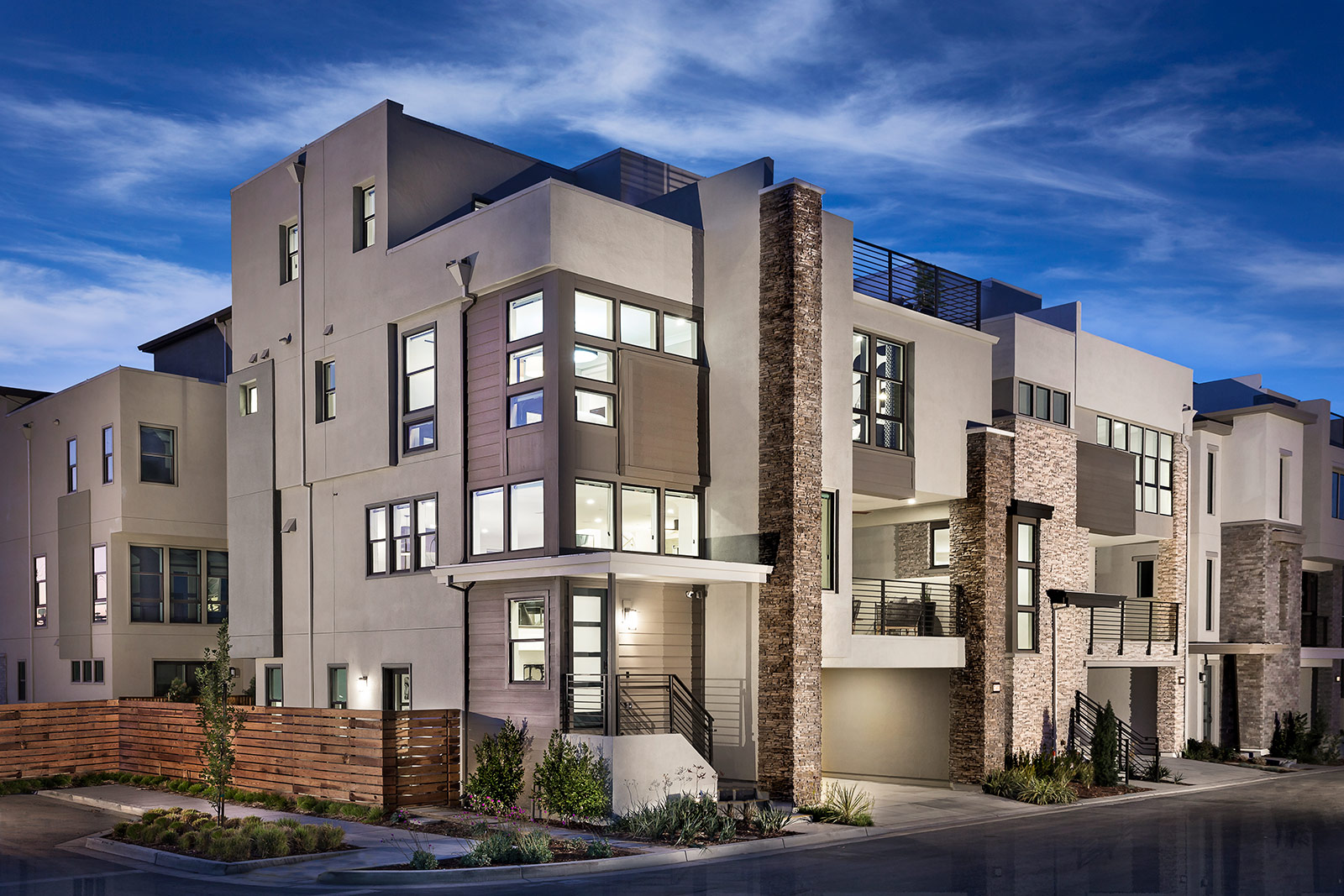 Modern bedroom by SummerHill Homes with accent wall, large bed, and balcony access.