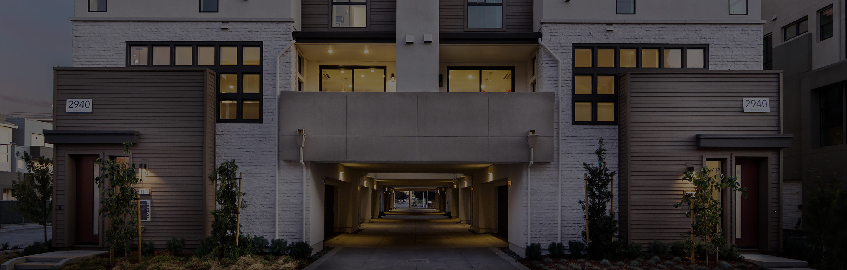 Two-story Mediterranean-style home by SummerHill Homes illuminated at dusk, featuring arched entryways and a tiled roof.